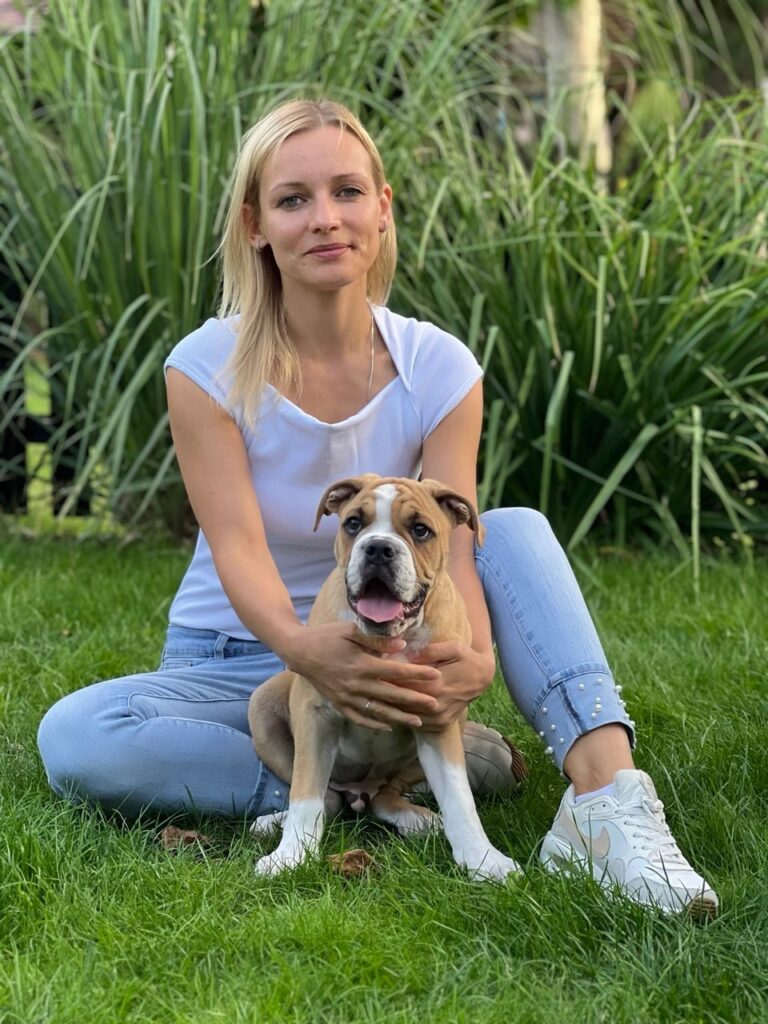 Daria, Gründerin von JollyDog, mit ihrem Hund im Garten
